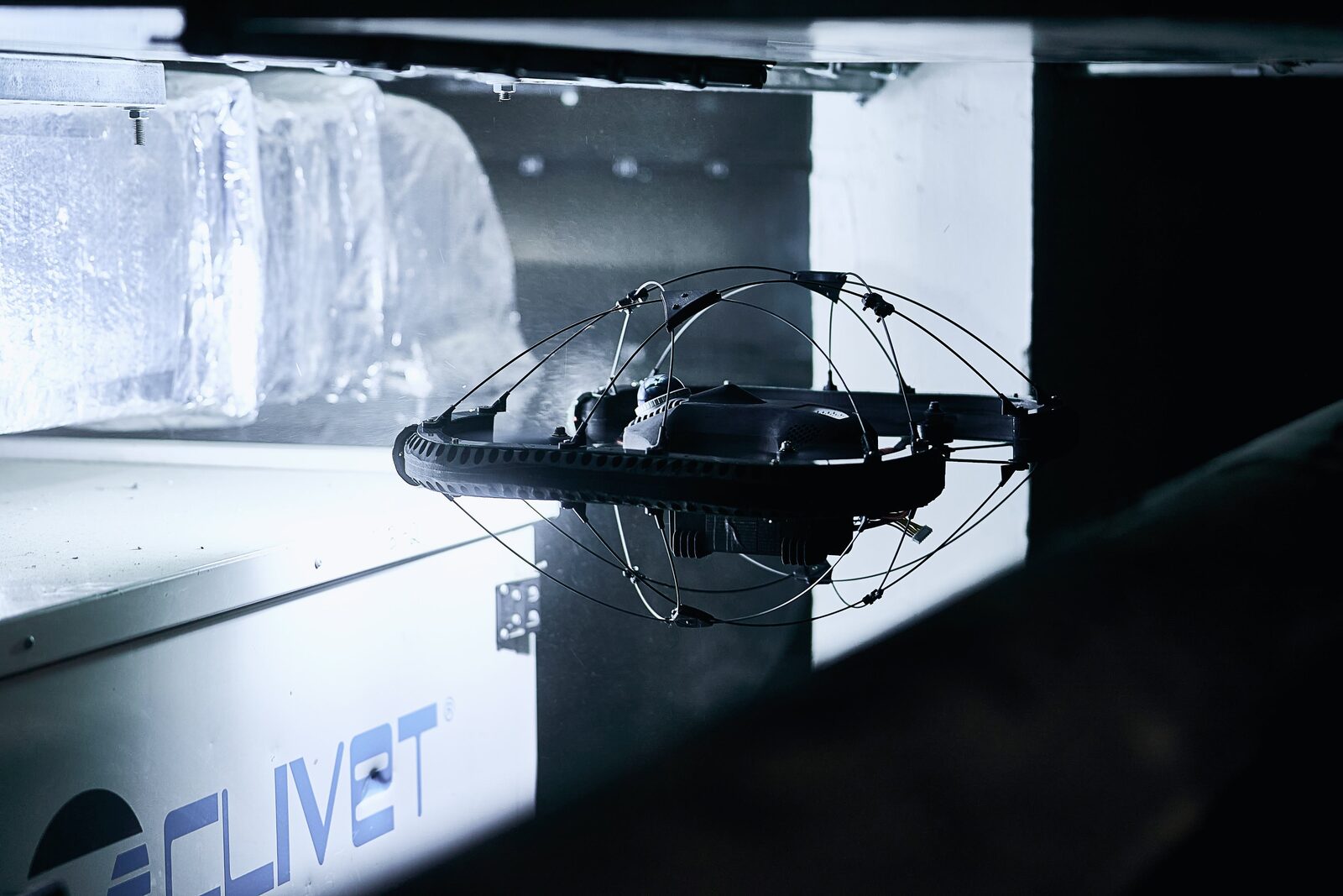 Close-up of the caged drone in an industrial hall